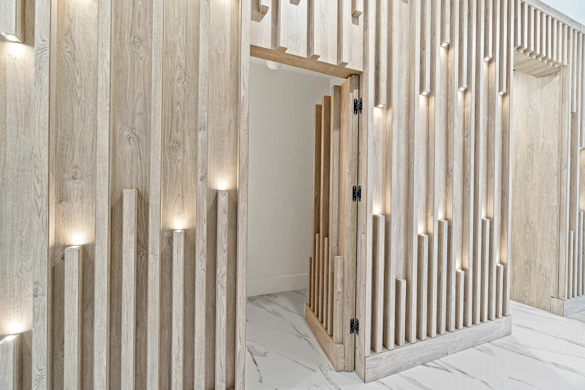 Hidden door integrated into illuminated vertical wood paneling in a designlab Northern Virginia whole home remodel
