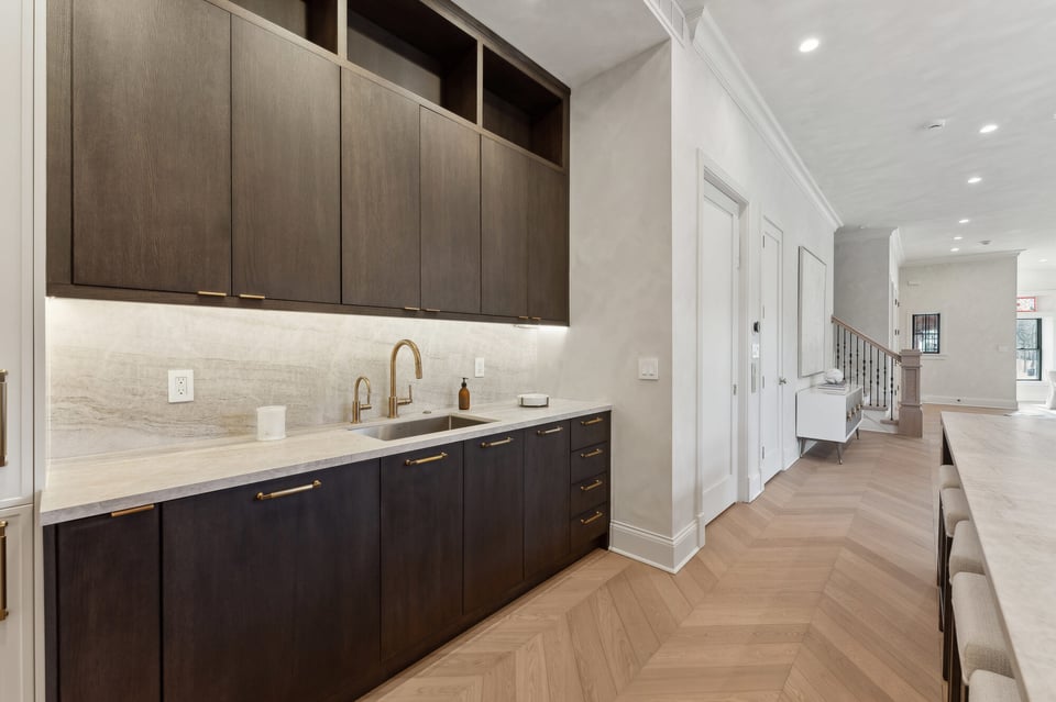 Sleek dark wood cabinetry with marble backsplash in luxury kitchen by DesignLab in McLean, VA
