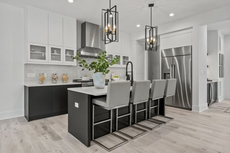 Sleek modern kitchen with black and white cabinetry and island seating in a River Oaks whole home by DesignLab