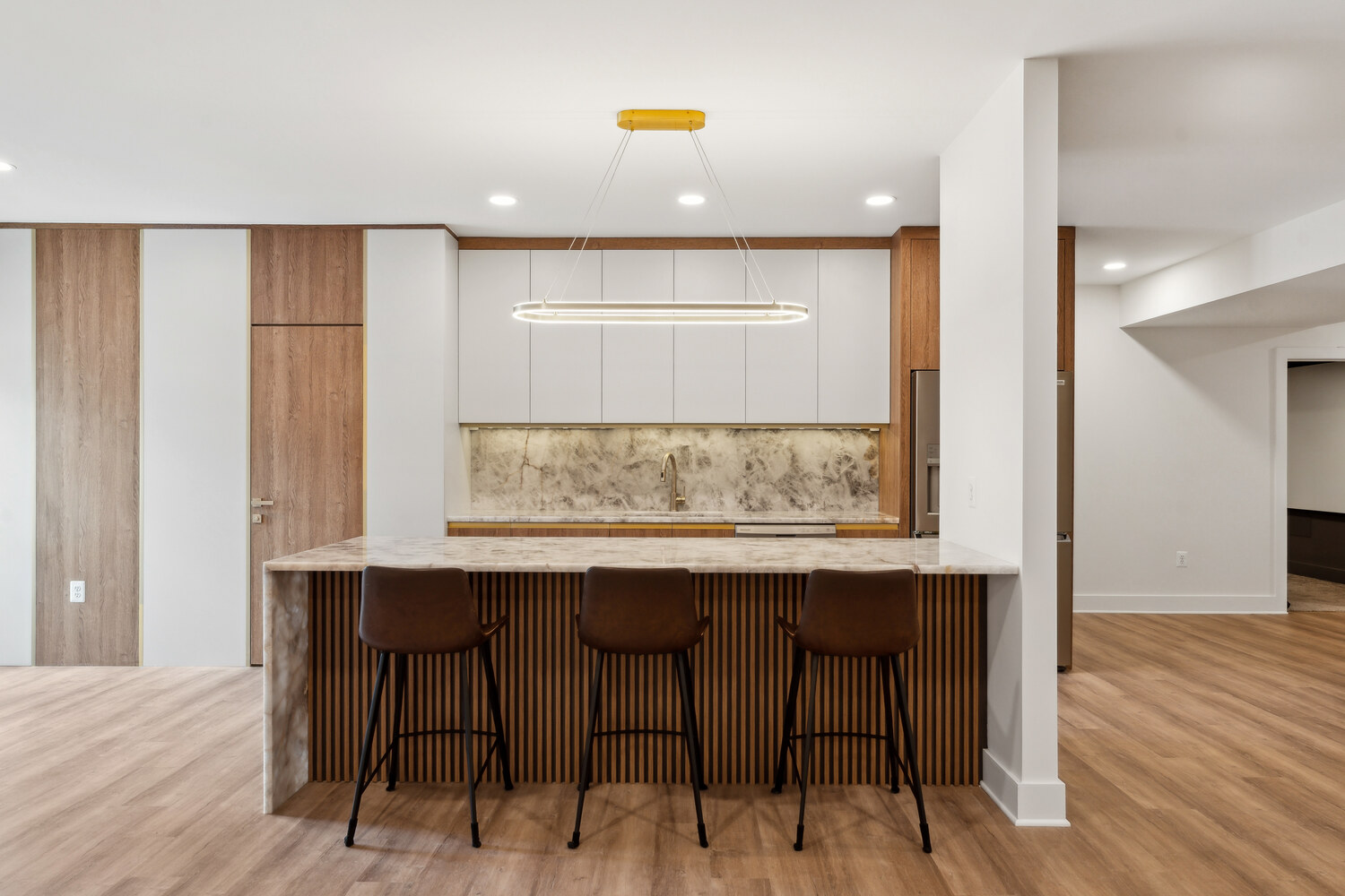 Modern kitchen remodel with marble island and wood accents by DesignLab in Metro Washington