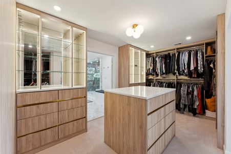 Spacious walk-in closet renovation with custom wood cabinetry and island by DesignLab in Metro Washington