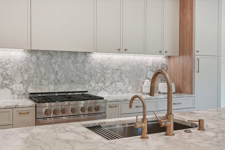 Sleek marble countertop and backsplash kitchen remodel in a Metro Washington custom home by DesignLab