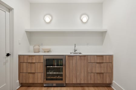 Wet bar with wood cabinetry and beverage cooler in DesignLab’s Washington, DC home