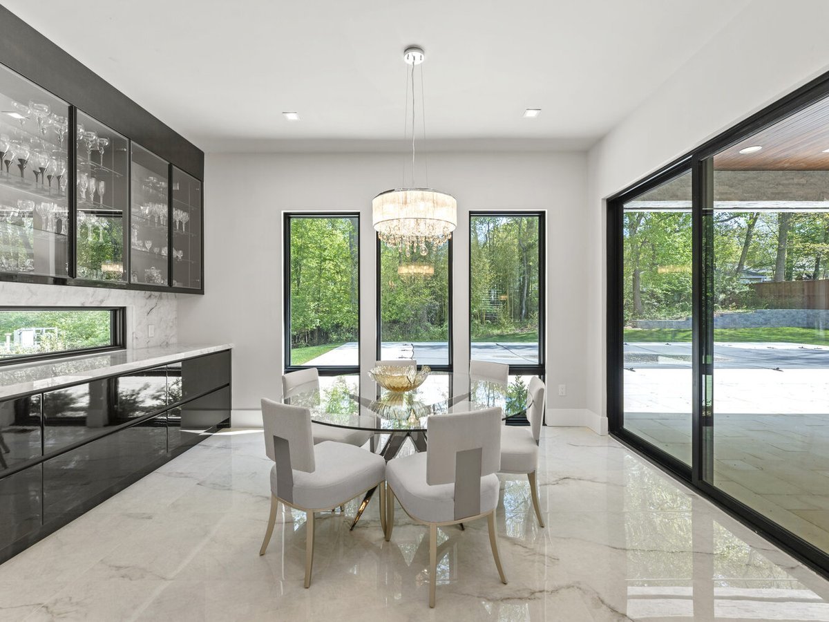Bright breakfast nook with glass table and large windows by DesignLab in Northern Virginia