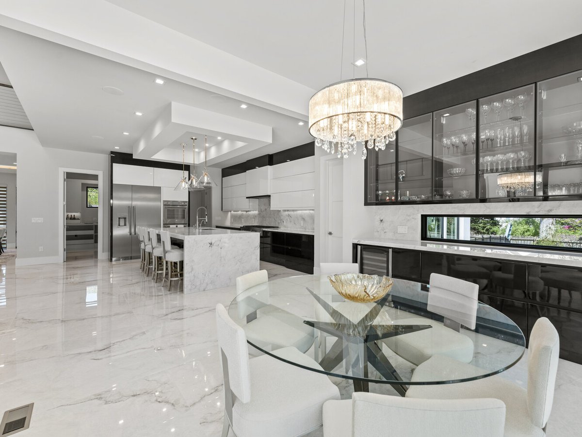 Contemporary dining area with chandelier and glass cabinets in Northern Virginia by DesignLab