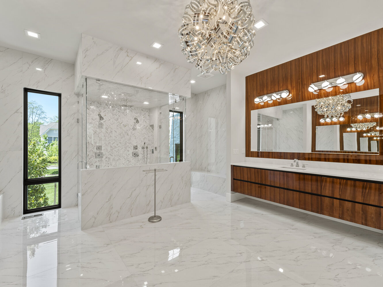 Lavish bathroom with dual showerheads and chandelier in a DesignLab custom home in Great Falls, VA