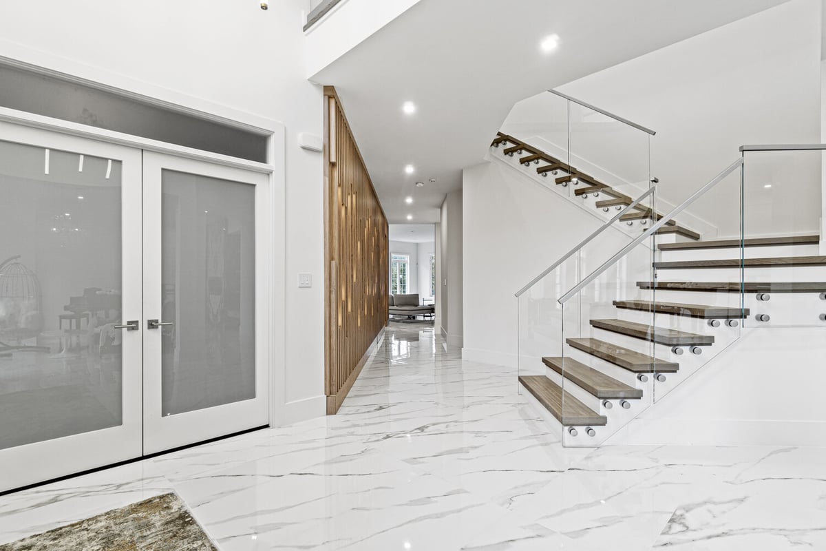 Entryway with glass staircase and accent wood paneling in Northern Virginia whole home remodel by designlab