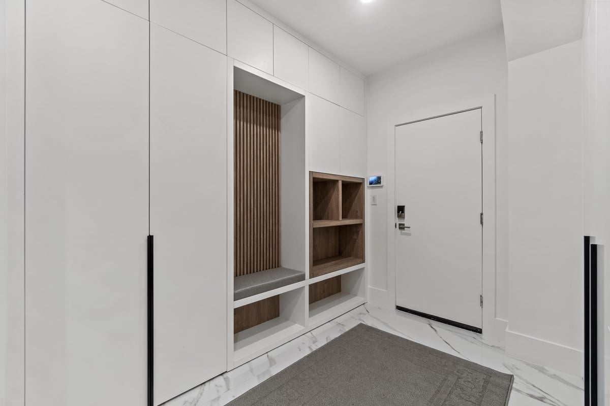 White mudroom with wood shelving and bench seating in Northern Virginia remodel by designlab