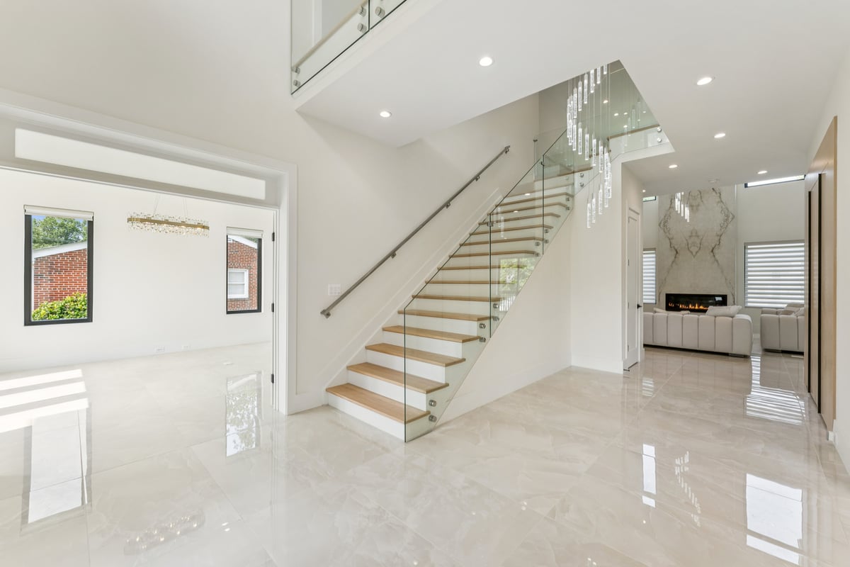 Sleek staircase remodel with glass railing by DesignLab in Arlington, Virginia
