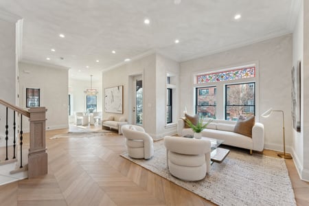 Light-filled living room with neutral seating and stained glass accents in a custom Rhode Island home by DesignLab