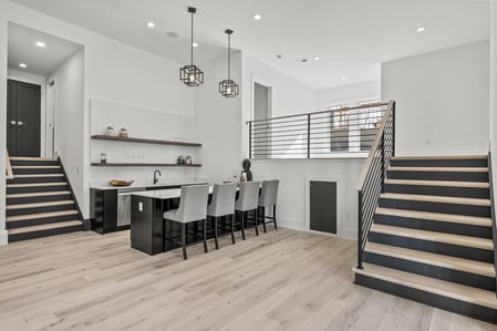 Basement wet bar with island seating and open shelving in River Oaks home by DesignLab
