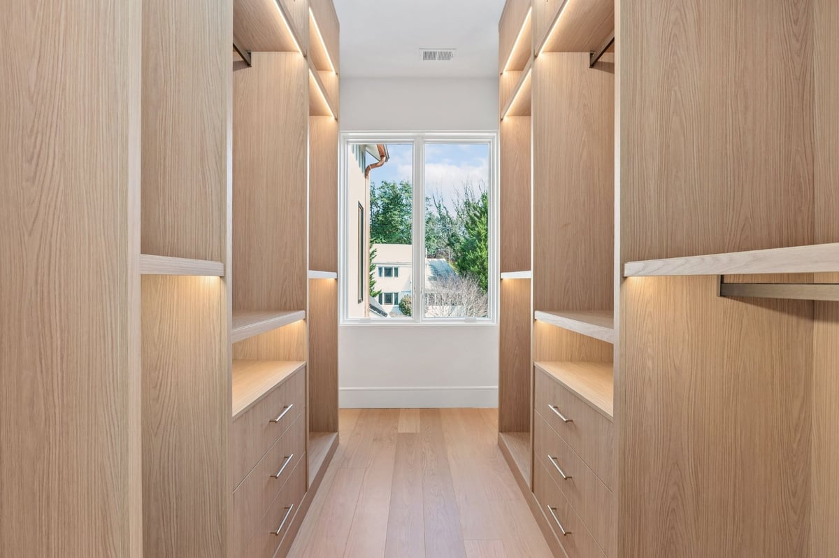 custom closet with built in shleving and custom lighting