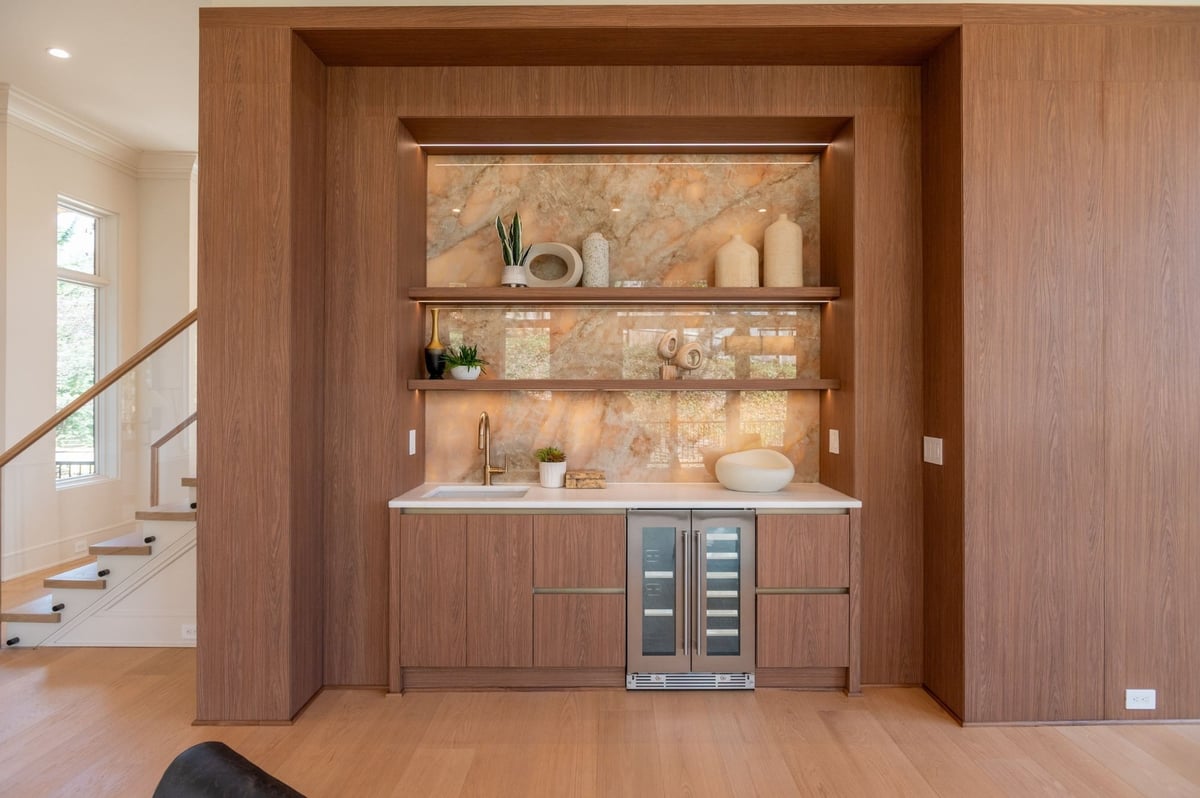 luxury wet bar with custom lit shelving and statement stonework
