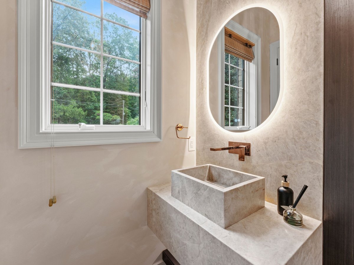 High end bathroom remodel in washington dc with backlit mirror and stone sink