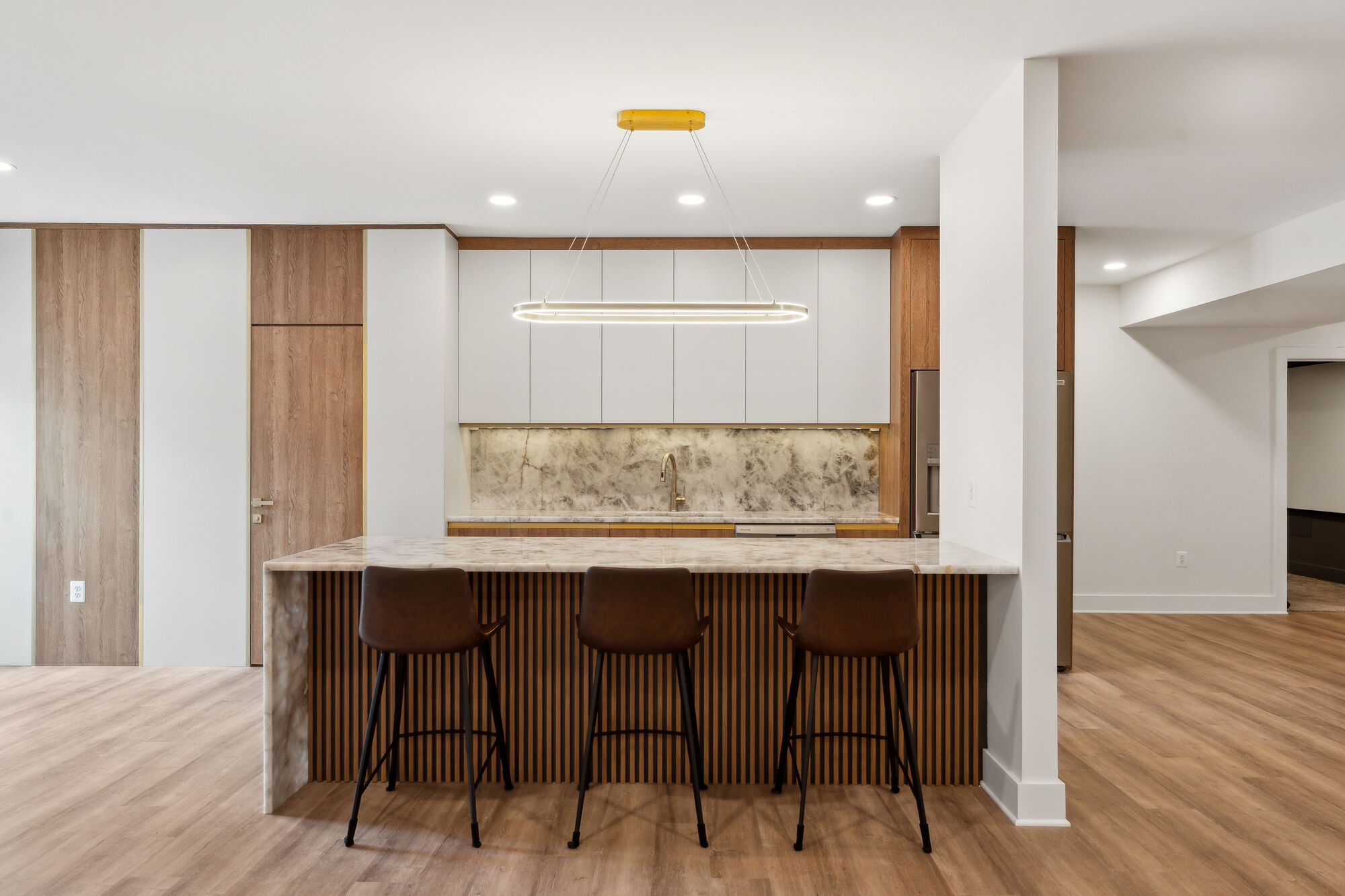 Modern kitchen remodel with marble island and wood accents by DesignLab in Metro Washington