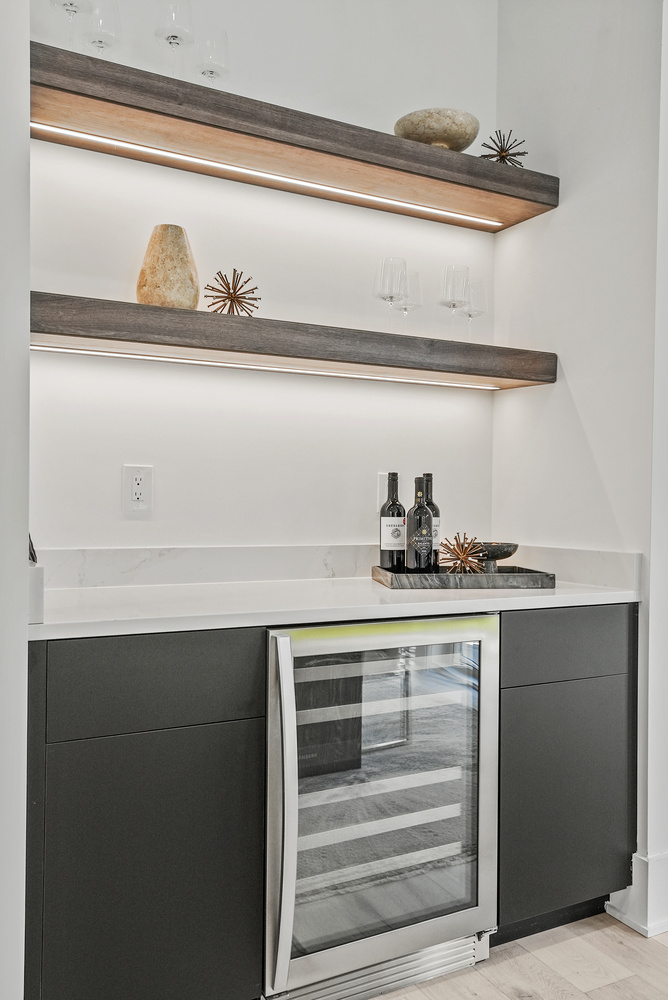 Compact wine bar with floating shelves and accent decor in a custom home by DesignLab in Capitol Hill, DC
