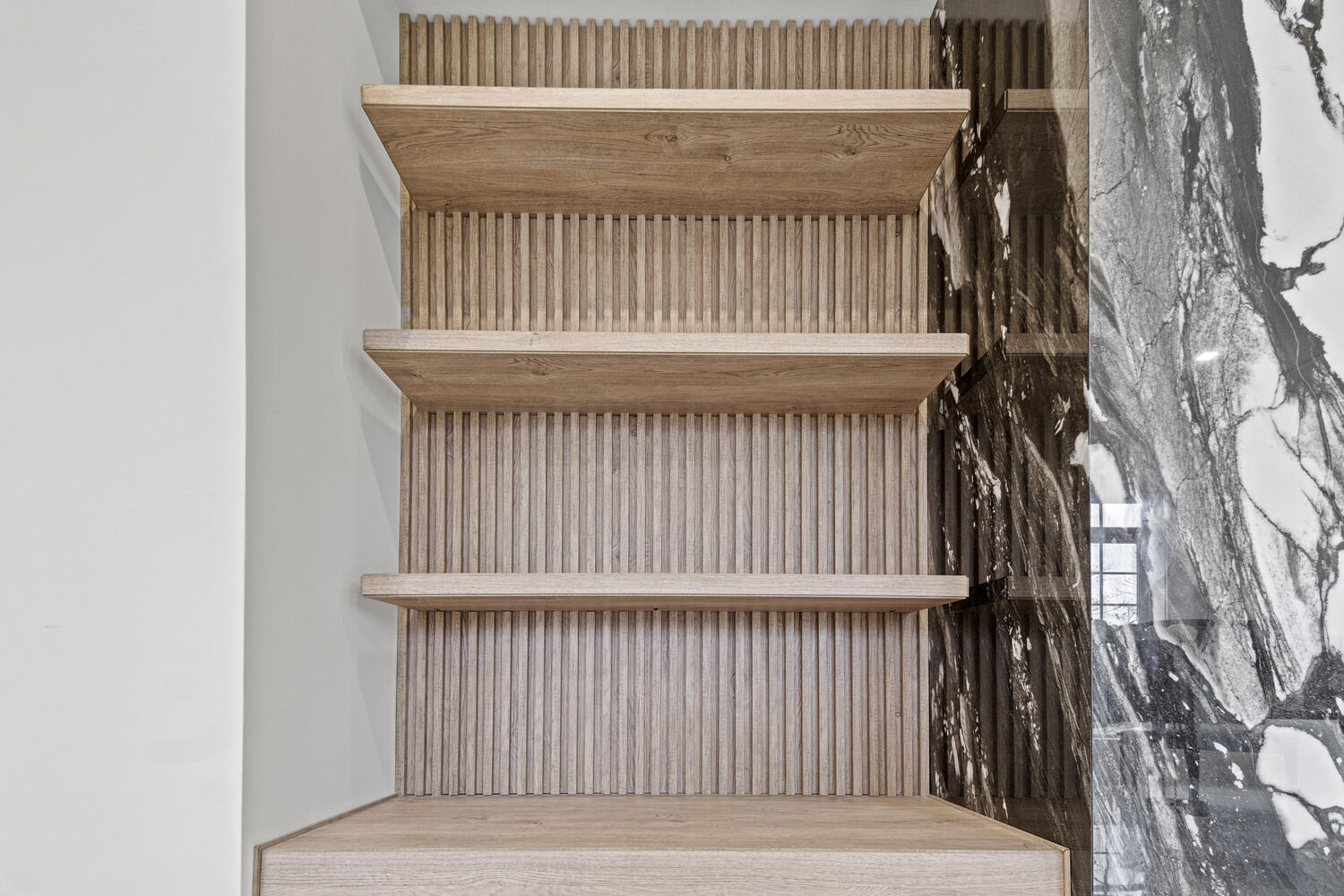 Modern floating wood shelves with vertical slat wall in a custom home by DesignLab in Oakton, VA