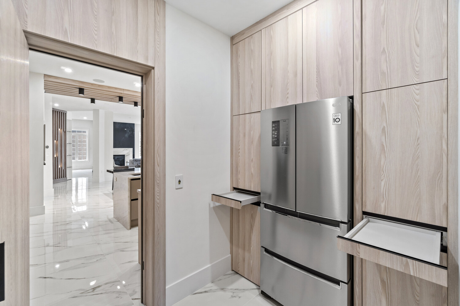 Modern kitchen with hidden pull-out trays beside the fridge in a DC-area custom home by DesignLab