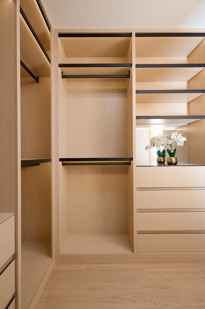 Minimalist walk-in closet with natural wood tones designed by DesignLab in McLean, VA