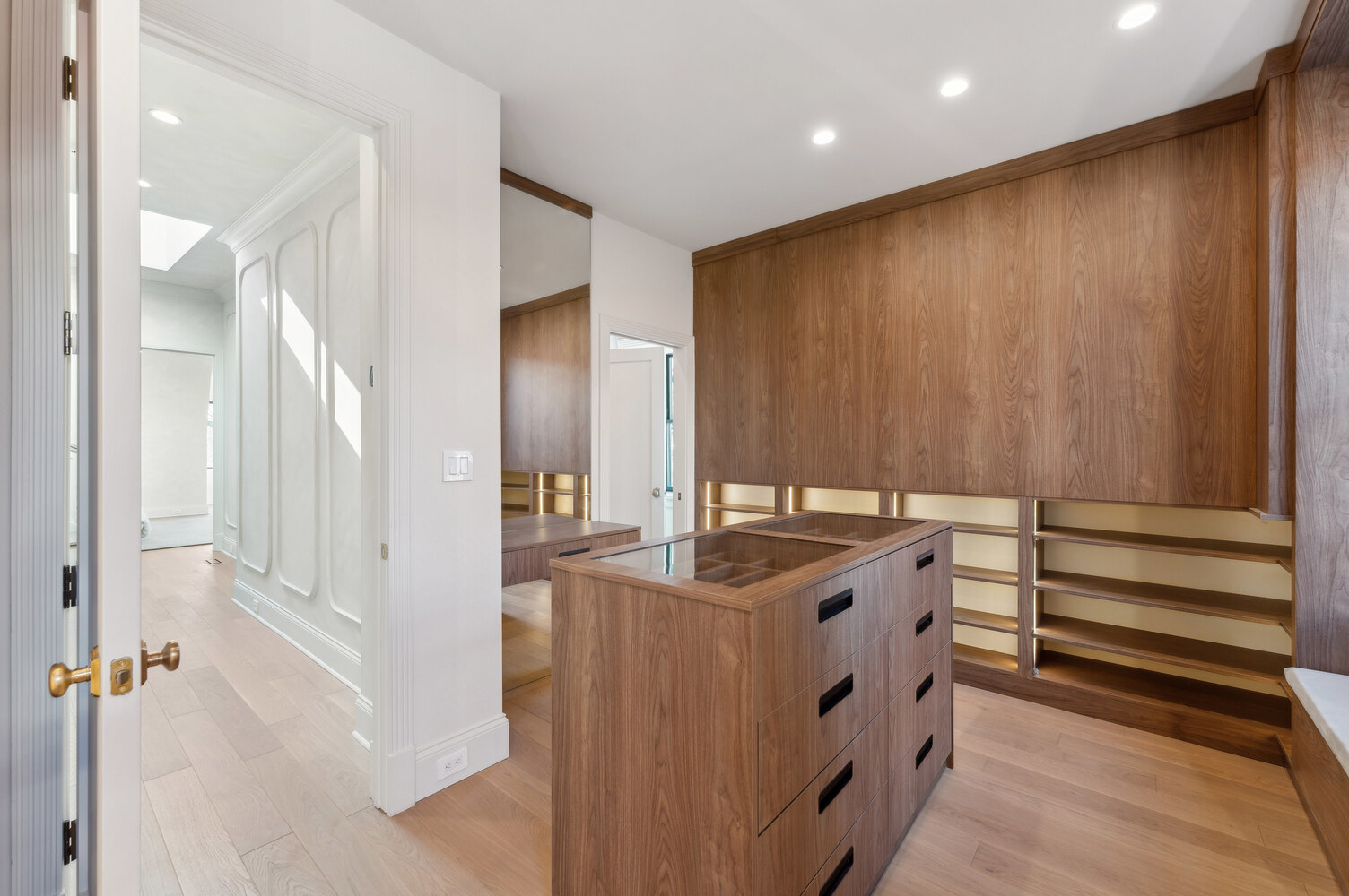 Open view into a high-end walk-in closet with soft-toned woodwork by DesignLab in Falls Church, VA