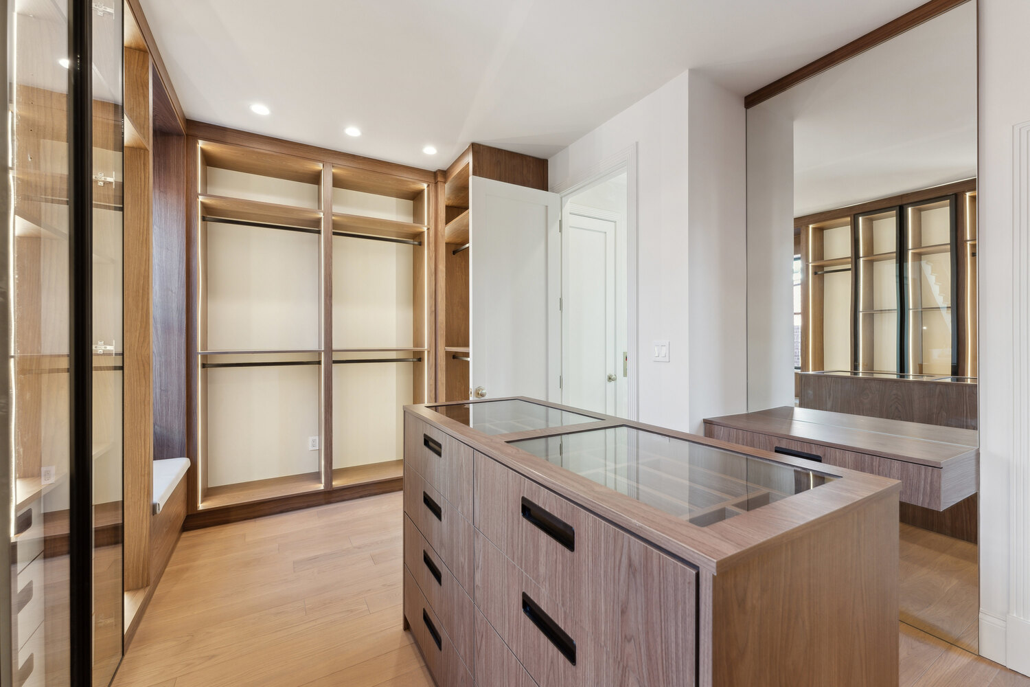 Spacious custom closet with large mirror, storage island, and wood details by DesignLab in Washington, DC