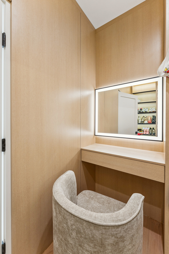Wood-paneled vanity nook with lighted mirror and plush chair by DesignLab in Georgetown, DC