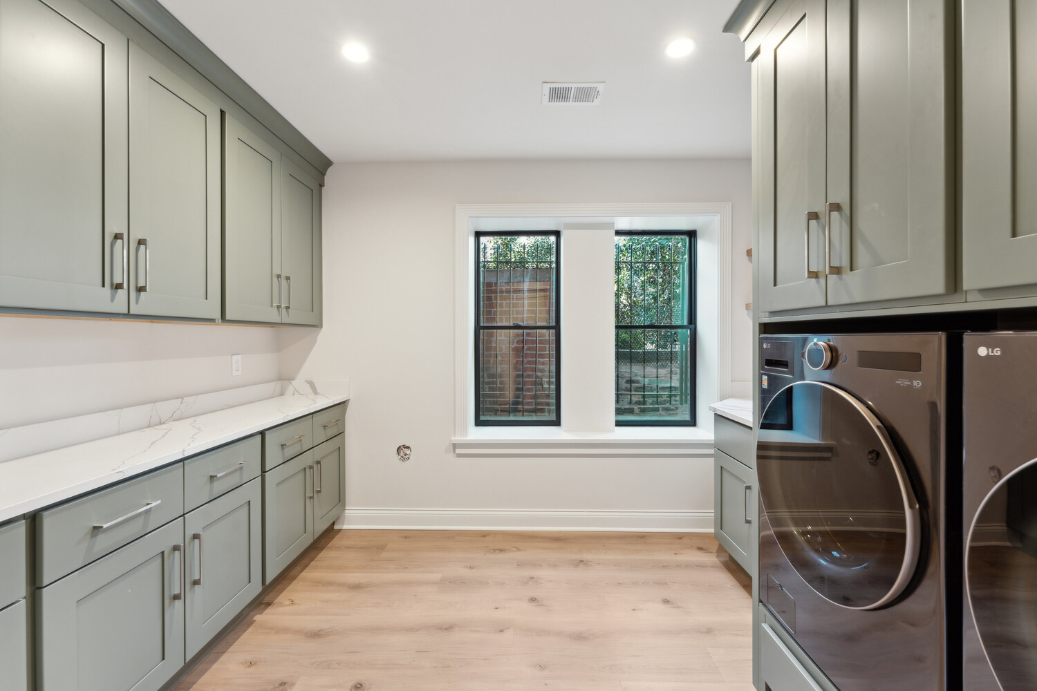 Bright and modern laundry space with dual windows and abundant storage by DesignLab in Metro Washington