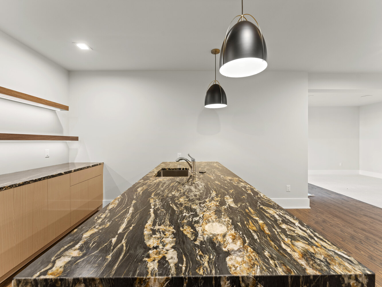 Modern basement bar with striking marble countertop and matte black pendants by DesignLab in Metro Washington