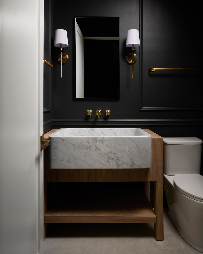 Modern powder room with dark walls, marble sink, and gold fixtures by DesignLab in Metro Washington