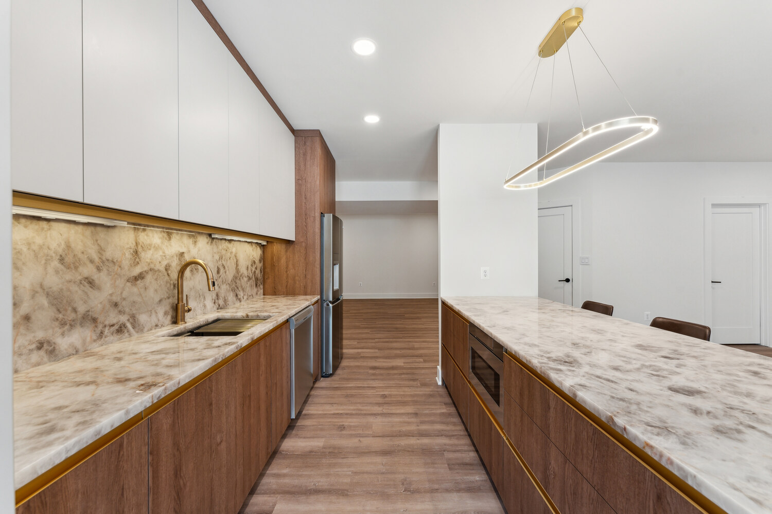 Wide-angle view of kitchen with island seating, pendant light, and dual-tone cabinetry by DesignLab in Metro Washington
