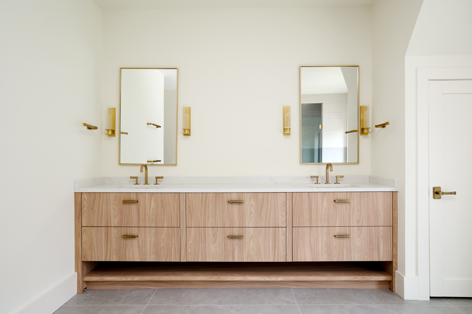 Custom double vanity with gold framed mirrors in a Bethesda bathroom project by DesignLab