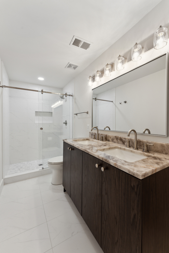 Double sink vanity with marble top and glass shower in a DesignLab custom home in Oakton, VA