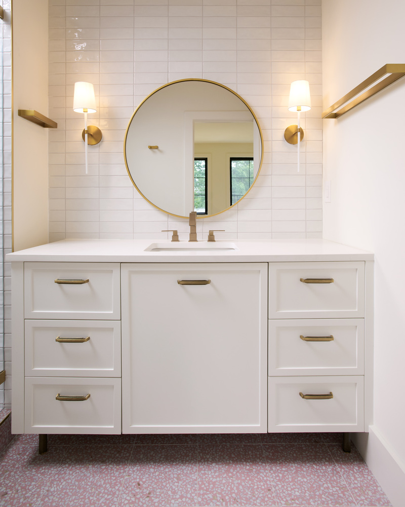 White bathroom vanity with round mirror in a DesignLab custom home in Georgetown, DC