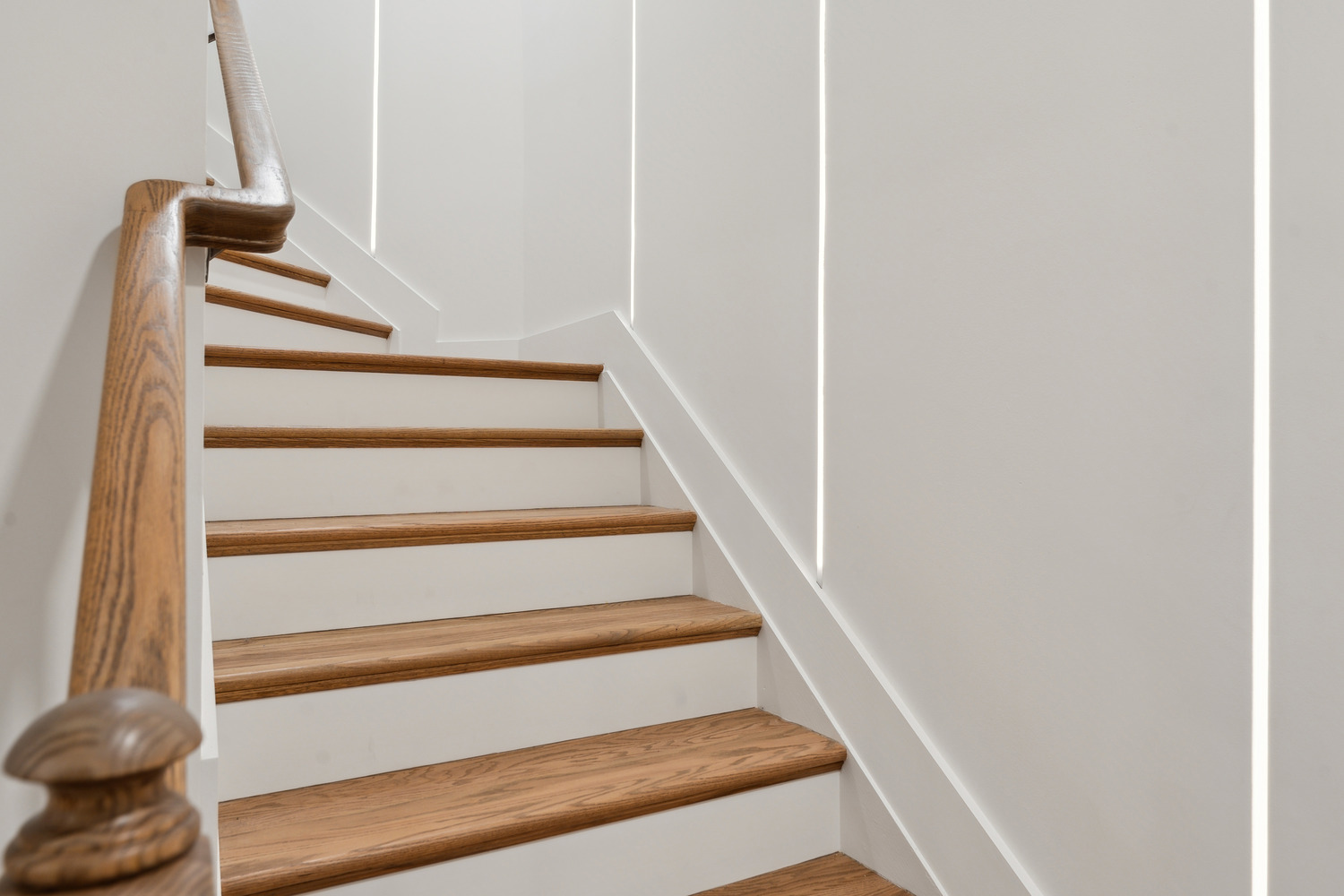 Light oak staircase design with clean white trim by DesignLab in a custom home in Kalorama, DC